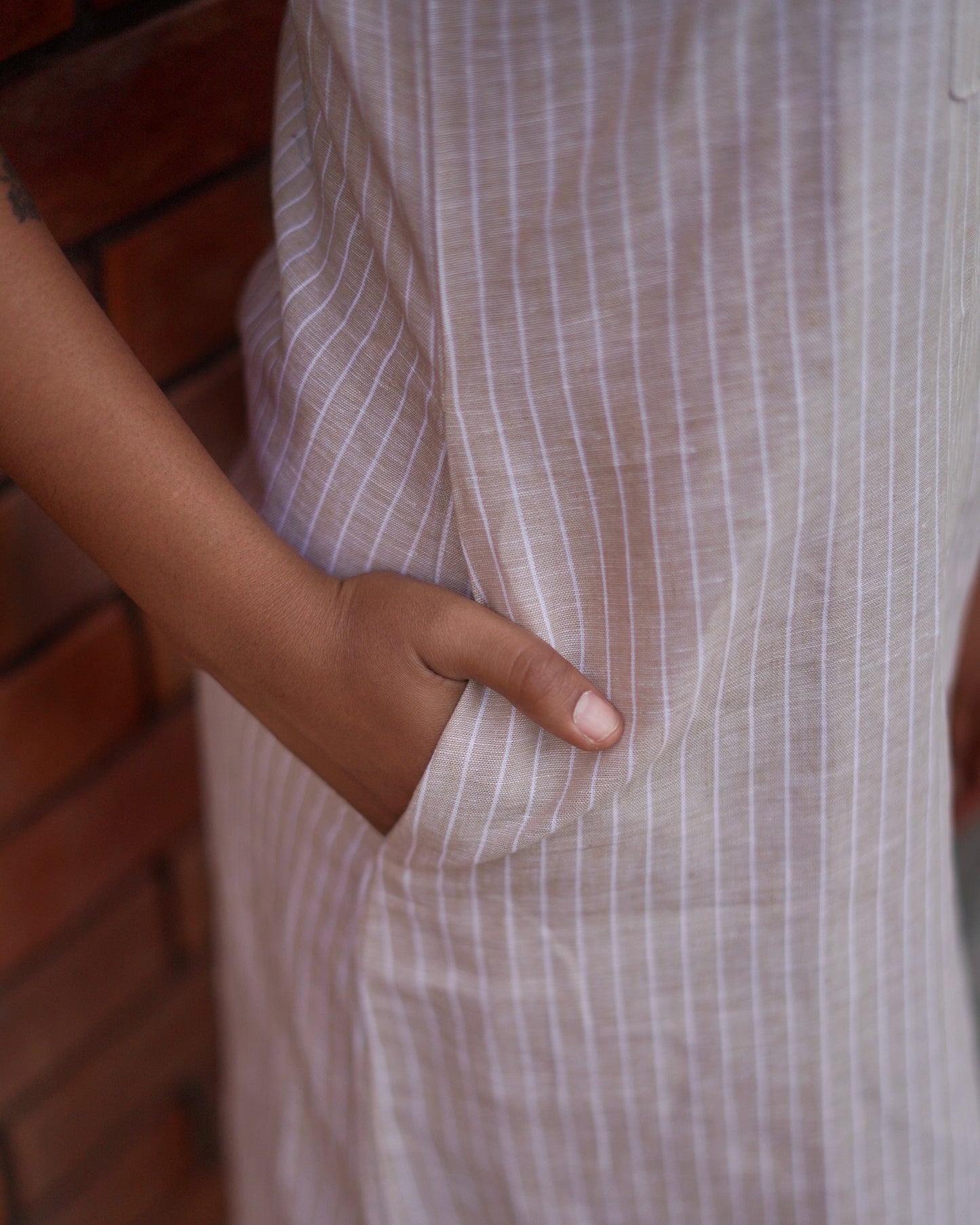 lose-up of the left side pocket below the waist, highlighting the Cozy One-Piece Pinafore’s functional and stylish detailing.