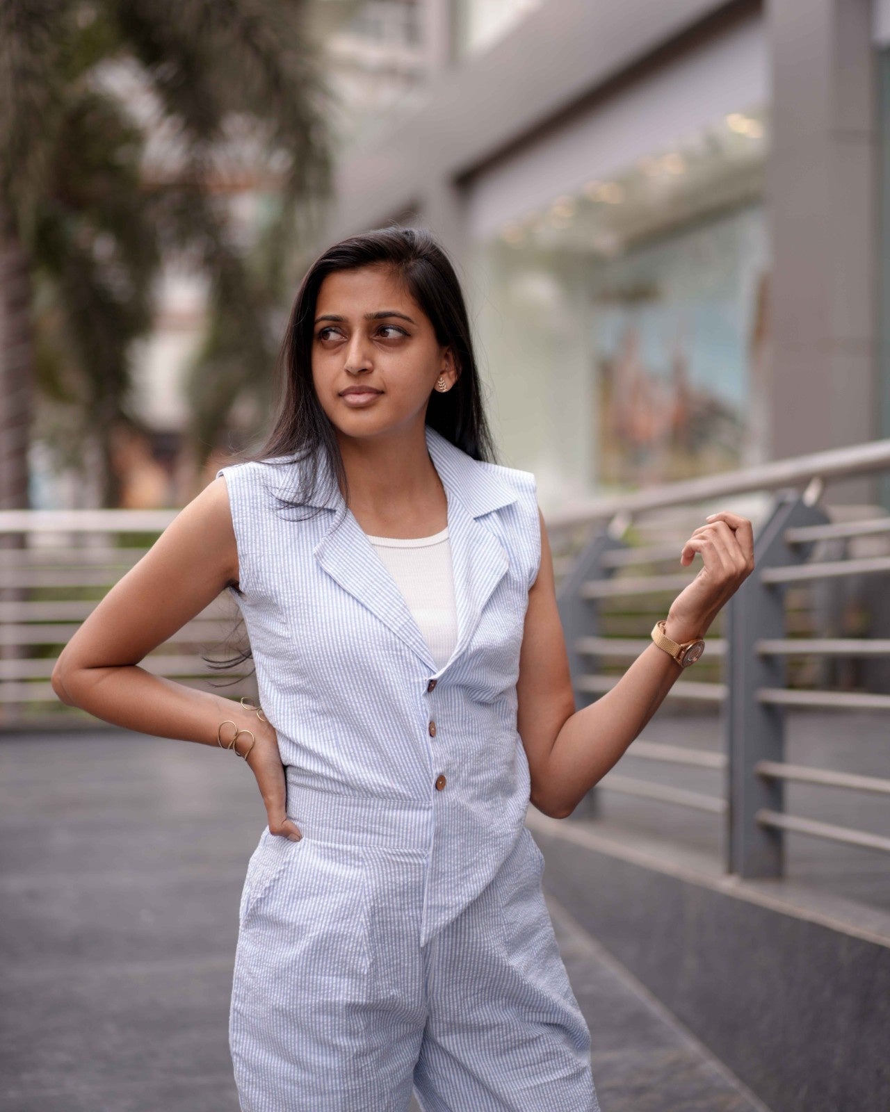 Close-up of a woman elegantly posing on a lawn pathway in the Anki Jumpsuit, highlighting its breathable and lightweight fabric.