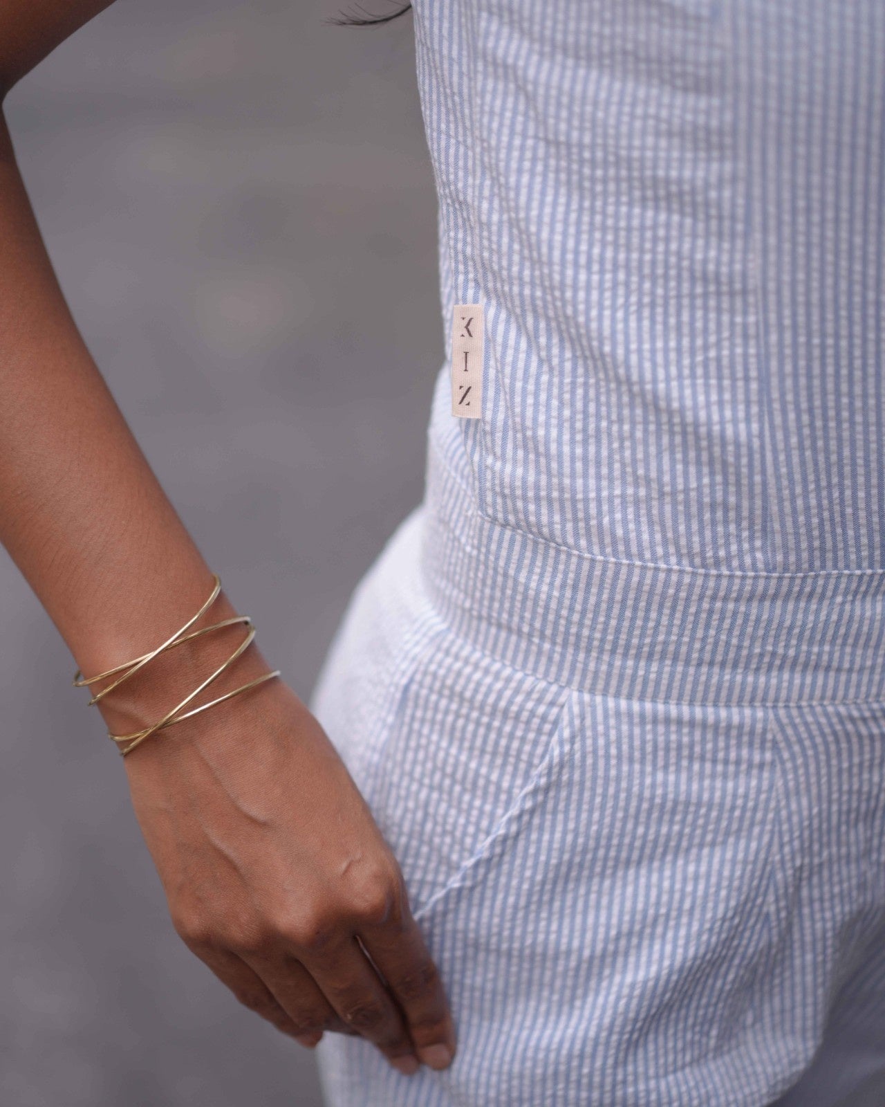 Right-side close-up of the Anki Jumpsuit, highlighting the brand logo and a modern bangle for a sophisticated touch.
