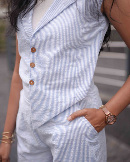 Zoomed-in close-up of a woman wearing a rose gold watch with hands inside pockets, emphasizing the comfort of the Anki Jumpsuit.