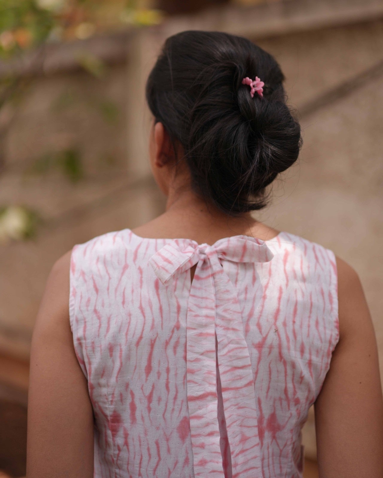 Close-up of the back torso in the Vil Top, focusing on the pony tie detail and soft, lightweight Shibori Mul Mul Cotton fabric.