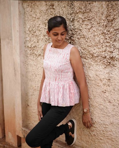 A woman casually leans on a wall in the Vil Top, gazing at little wonders to her left, exuding a relaxed and effortless style.
